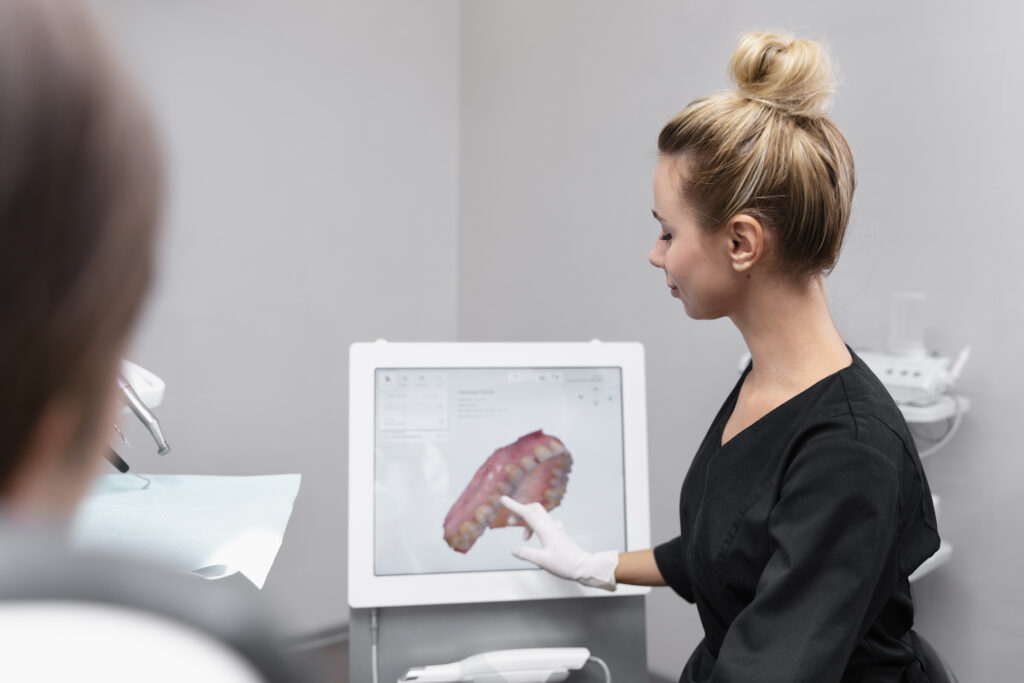 Dentist reviewing 3D digital full mouth dental implant treatment plan with patient on computer screen